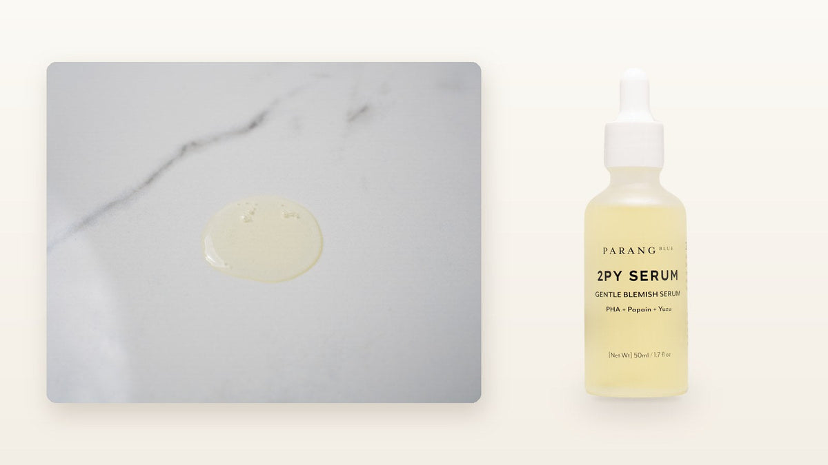 A drop of 2PY Serum on marble next to the Parang Blue serum bottle