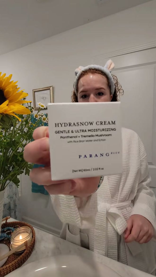 A Calm Skin Project reviewer holding the Hydrasnow Cream carton